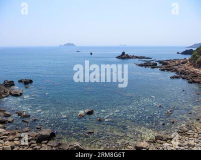 Barche da pesca nel Mar Cinese meridionale al largo delle coste rocciose di Eo Gió nella provincia di Bình Định, Vietnam Foto Stock