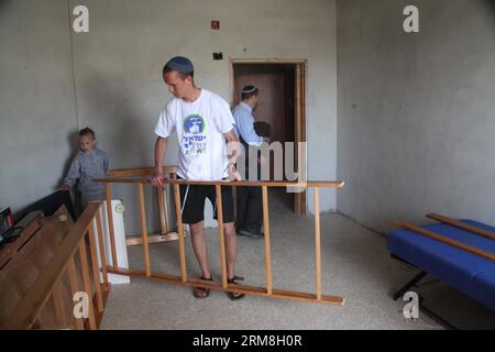 Un colono israeliano sposta i mobili in un controverso edificio di quattro piani nella città di Hebron, in Cisgiordania, il 13 aprile 2014. Il ministro della difesa israeliano Moshe Ya alon domenica ha autorizzato le famiglie di coloni ebrei a trasferirsi in un edificio controverso nella vecchia città di Hebron in Cisgiordania, hanno riferito i media israeliani. (Xinhua/Mamoun Wazwaz) MIDEAST-HEBRON-ISRAELI SETTLERS PUBLICATIONxNOTxINxCHN to Israeli Settler sposta I MOBILI in un controverso edificio a quattro piani nella città di Hebron IN CISGIORDANIA IL 13 aprile 2014 I ministri della difesa israeliani Moshe Ya Alon LA domenica hanno autorizzato IL Settler ebraico Foto Stock