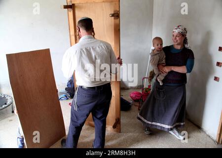 Un colono israeliano sposta i mobili in un controverso edificio di quattro piani nella città di Hebron, in Cisgiordania, il 13 aprile 2014. Il ministro della difesa israeliano Moshe Ya alon domenica ha autorizzato le famiglie di coloni ebrei a trasferirsi in un edificio controverso nella vecchia città di Hebron in Cisgiordania, hanno riferito i media israeliani. (Xinhua/Mamoun Wazwaz) MIDEAST-HEBRON-ISRAELI SETTLERS PUBLICATIONxNOTxINxCHN to Israeli Settler sposta I MOBILI in un controverso edificio a quattro piani nella città di Hebron IN CISGIORDANIA IL 13 aprile 2014 I ministri della difesa israeliani Moshe Ya Alon LA domenica hanno autorizzato IL Settler ebraico Foto Stock