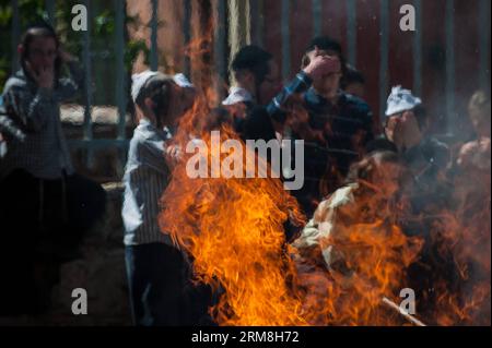 Gli ebrei ultra-ortodossi bruciano il cibo lasciato in eredità a Mea Shearim a Gerusalemme, il 14 aprile 2014. Durante la Pasqua, mangiare chametz, pane e altro cibo fatto con grano lievito è vietato secondo la legge religiosa ebraica. Pesach è un importante festival ebraico biblicamente derivato. Il popolo ebraico celebra la Pasqua come una commemorazione della loro liberazione oltre 3.300 anni fa da Dio dalla schiavitù nell'antico Egitto governato dai faraoni, e la loro libertà come nazione sotto la guida di Mosè. (Xinhua/li Rui) MIDEAST-JERUSALEM-PASSOVER-LEAVENED FOOD-BURNING PUBLICATIONxNOTxINx Foto Stock