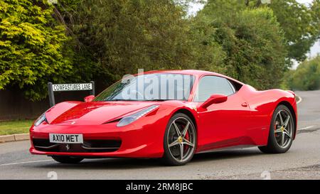 Whittlebury, Northants, Regno Unito - 26 agosto 2023: 2013 auto rossa Ferrari 458 Italia che viaggia su una strada di campagna inglese Foto Stock