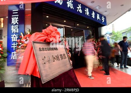 (140423) -- PECHINO, 23 aprile 2014 (Xinhua) -- la gente entra nella libreria Sanlian Taofen a Pechino, capitale della Cina, 23 aprile 2014. La prima libreria di Pechino, aperta 24 ore su 24, Sanlian Taofen Bookstore, ha ufficialmente aperto il mercoledì. La libreria nel distretto di Dongcheng ha ampliato le sue ore di apertura 24 ore su 24 l'8 aprile e da allora ha venduto più di 650.000 yuan (105.519 dollari USA) di libri. (Xinhua/Jin Liangkuai) (zkr) CINA-PECHINO-LIBRERIA APERTA 24 ORE su 24(CN) PUBLICATIONxNOTxINxCHN Pechino 23 aprile 2014 le celebrità di XINHUA entrano nella libreria Sanlian Taofen a Pechino capita Foto Stock