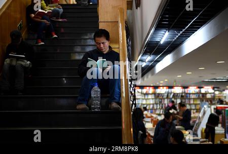 (140423) -- PECHINO, 23 aprile 2014 (Xinhua) -- la gente legge libri alla libreria Sanlian Taofen di Pechino, capitale della Cina, 23 aprile 2014. La prima libreria di Pechino, aperta 24 ore su 24, Sanlian Taofen Bookstore, ha ufficialmente aperto il mercoledì. La libreria nel distretto di Dongcheng ha ampliato le sue ore di apertura 24 ore su 24 l'8 aprile e da allora ha venduto più di 650.000 yuan (105.519 dollari USA) di libri. (Xinhua/Jin Liangkuai) (zkr) (FOCUS)CINA-PECHINO-LIBRERIA APERTA 24 ORE su 24(CN) PUBLICATIONxNOTxINxCHN Pechino 23 aprile 2014 XINHUA Celebrities Read Books AT Sanlian Taofen Bookstore a Pechino Foto Stock