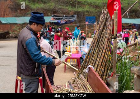 Cầu Cán Tỷ, Vietnam - 27 gennaio 2020: Venditore che si prepara a vendere succo di canna da zucchero in un mercato di cibo di strada sul fiume Sông Lô sul circuito ha Giang Foto Stock