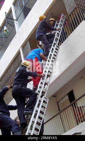 SURAT, 29 aprile 2014 (Xinhua) - il personale dei Vigili del fuoco aiuta i residenti a scendere dai loro appartamenti nel sito di collasso nel distretto di Surat nel Gujarat, India, 29 aprile 2014. Almeno tre persone, tra cui due bambini, sono rimaste uccise e altre cinque sono rimaste gravemente ferite quando le lastre di sei piani di un edificio residenziale a più piani crollarono nel distretto di Surat nel Gujarat, in India. (Xinhua/Stringer) INDIA-SURAT-COLLAPSE PUBLICATIONxNOTxINxCHN Surat aprile 29 2014 il personale dei Vigili del fuoco di XINHUA aiuta i residenti a scendere dalle loro DISTESE PRESSO il sito di collasso nel distretto di Surat nel Gujarat in India Foto Stock