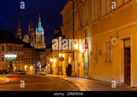Praga, Repubblica Ceca - 6 agosto 2017: Vista notturna delle case storiche in via Loretánská a Praga, con la Cattedrale di San Cattedrale di Vito sullo sfondo Foto Stock
