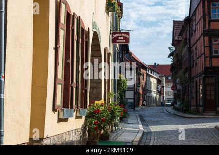 Wernigerode, Germania - 15 agosto 2017: Strada tranquilla con vasi di fiori e pittoresche case in legno nel centro storico di Wernigerode Foto Stock