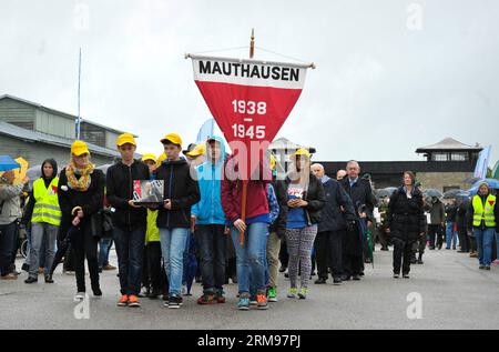 (140512) -- VIENNA, 12 maggio 2014 (Xinhua) -- i sopravvissuti del campo di concentramento di Mauthausen e gli adolescenti marciano durante una cerimonia che segna il 69° anniversario della liberazione del campo di concentramento di Mauthausen in alta Austria, 11 maggio 2014. Il campo di concentramento di Mauthausen fu il primo del suo genere istituito in un paese straniero dalla Germania nazista. Era uno dei campi più famosi del sistema dei campi di concentramento nazisti. (Xinhua/Qian Yi) AUSTRIA-CAMPO DI CONCENTRAMENTO DI MAUTHAUSEN - ANNIVERSARIO PUBLICATIONxNOTxINxCHN Vienna 12 maggio 2014 XINHUA sopravvissuti del campo di concentramento di Mauthausen e Teenag Foto Stock