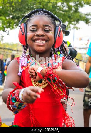 Londra, Regno Unito, 27 agosto 2023. Aliah, una giovane partecipante del gruppo con sua madre, si diverte a ballare alla parata. Gruppo mas Caribbean Sessions e giovani ballerini. Il carnevale di Notting Hill inizia con il carnevale dei bambini e con un percorso per famiglie. Si prevede che fino a due milioni di persone celebrino il carnevale di questo fine settimana festivo partecipando o guardando lungo il percorso del carnevale, presso impianti sonori, bancarelle e locali. Polveri e pitture colorate, in riconoscimento della tradizione caraibica e inizio delle festività del Carnevale di Notting Hill. Foto Stock