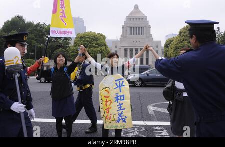 (140513) -- TOKYO, 13 maggio 2014 (Xinhua) -- la gente tiene una manifestazione per protestare contro il piano del governo di approvare la difesa collettiva proprio di fronte all'edificio del parlamento a Tokyo, capitale del Giappone, 13 maggio 2014. Il primo ministro giapponese Shinzo Abe annuncerà la posizione di base del suo governo sulla difesa collettiva proprio giovedì prossimo. (Xinhua/Stinger) JAPAN-TOKYO-PROTEST PUBLICATIONxNOTxINxCHN Tokyo 13 maggio 2014 le celebrità di XINHUA tengono una dimostrazione per protestare contro il piano del governo di approvare la difesa collettiva proprio di fronte al Parlamento di Tok Foto Stock