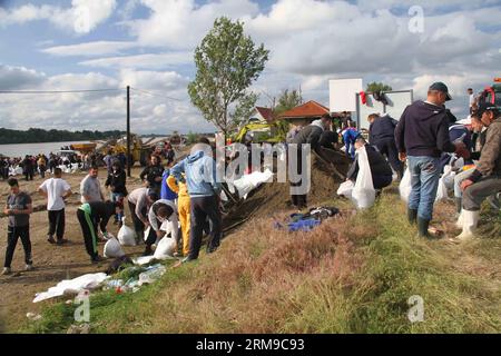 La gente costruisce terrapieni riempiendo i sacchi di sabbia e costruendoli in un muro per proteggerli dalle inondazioni a Umka di Belgrado, Serbia, il 17 maggio 2014. In una breve pausa di piogge, la Serbia si impegnò al massimo delle capacità per assicurare argini sul fiume Sava e salvare le persone nella città di Obrenovac, devastata dalle inondazioni. (Xinhua/Wang Hui) SERBIA-BELGRADO-INONDAZIONI-TERRAPIENI PUBLICATIONxNOTxINxCHN celebrità COSTRUISCONO terrapieni riempiendo i sacchi di sabbia e costruendoli in un muro per proteggerli dalle inondazioni a Belgrado in Serbia IL 17 maggio 2014 in breve Break of Rainfall Serbia ha impegnato Maximum to Secure embankme Foto Stock