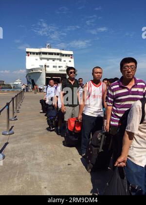 (140520) -- HAIKOU, 20 maggio 2014 (Xinhua) -- cittadini cinesi sbarcano dalla nave passeggeri Wuzhishan dopo che la nave è arrivata al porto Xiuying di Haikou, capitale della provincia di Hainan della Cina meridionale, il 20 maggio 2014. Il primo gruppo di lavoratori cinesi colpiti dalla violenza in Vietnam è arrivato al porto di Haikou martedì mattina. Domenica il governo cinese ha inviato quattro navi per evacuare i lavoratori cinesi colpiti dalla sommossa in Vietnam, dove dal 13 maggio le violenze violente contro le aziende straniere hanno causato la morte di due cittadini cinesi e oltre 100 feriti. (Xinhua/Xia Yifang) (lfj) CHIN Foto Stock