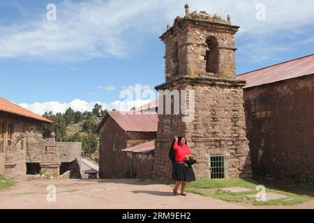 (140520) -- PUNO, 20 maggio 2014 (Xinhua) -- Una donna cammina su una strada sull'isola galleggiante di Taquile sul lago Titicaca, nella regione di Puno, Perù, 13 maggio 2014. Il lago Titicaca e le sue isole galleggianti nella regione di Puno del Perù hanno non solo attrazioni naturali, ma anche una cultura unica grazie alla popolazione quechua di Juliaca che vive lì. Il lago Titicaca si trova nell'altopiano di Collao, con le isole di Luna, Taquile, Amantani, Uros e Suriqui. (Xinhua/Luis Camacho)(zhf) PERÙ-PUNO-TITICACA LAKE-FLOATING ISLAND PUBLICATIONxNOTxINxCHN Puno 20 maggio 2014 XINHUA una donna cammina SU una strada SUL Foto Stock