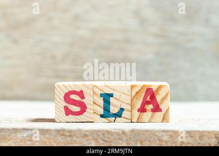 Blocco alfabetico in parola SLA (abbreviazione di Service Level Agreement) su sfondo legno Foto Stock