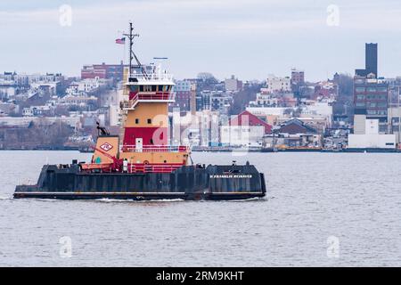 Un rimorchiatore nel porto di New York con Brooklyn sullo sfondo Foto Stock