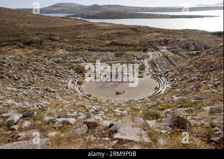 DELOS, 28 maggio 2014 (Xinhua) -- i turisti visitano i resti di un antico teatro sull'isola di Delos, Grecia, il 28 maggio 2014. Secondo la mitologia greca, Apollo è nato su questa piccola isola dell'arcipelago delle Cicladi. Il santuario di Apollo attirava pellegrini da tutta la Grecia e Delos era un prospero porto commerciale. L'isola presenta tracce delle civiltà che succedono nel mondo Egeo, dal III millennio a.C. all'era paleocristiana. Il sito archeologico è eccezionalmente esteso e ricco e trasmette l'immagine di un grande porto cosmopolita mediterraneo. (Xinhua/Liu Yon Foto Stock