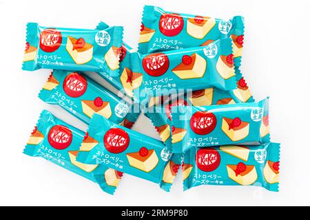 Diversi Kit Kat da bar Cheesecake giapponesi in una piccola pila su uno sfondo bianco semplice. Foto Stock