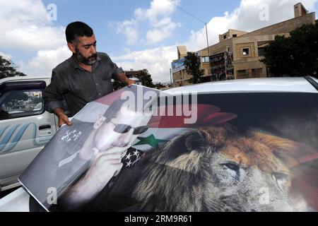 KARDAHA, (Xinhua) - Un uomo infila la foto del presidente siriano Bashar al-Assad sul finestrino di un'auto a Kardaha, Latakia, in Siria, il 26 maggio 2014, prima delle elezioni presidenziali previste per il 3 giugno. Kardaha è la città natale di Bashar al-Assad. (Xinhua/Zhang Naijie) SYRIA-KARDAHA-PRESIDENTIAL ELECTION-FEATURE PUBLICATIONxNOTxINxCHN XINHUA a Man Sticks l'immagine del presidente siriano Bashar al Assad SULLA finestra di un'auto in Siria IL 26 2014 maggio prima delle ELEZIONI presidenziali previste IL 3 giugno È la città natale di Bashar al Assad XINHUA Zhang Siria PUBLICATIO Foto Stock