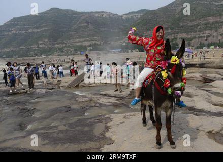 (140602) --YICHUAN, 2 giugno 2014 (Xinhua) -- Una donna posa per una foto vicino alla cascata Hukou del fiume giallo nella contea di Yichuan, nella provincia dello Shaanxi della Cina nord-occidentale, 2 giugno 2014. (Xinhua/Liu Xiao) (yxb) CINA-HUKOU CASCATA-PAESAGGIO (CN) PUBLICATIONxNOTxINxCHN Yichuan 2 giugno 2014 XINHUA una donna posa per una foto vicino alla cascata Hukou del fiume giallo nella contea di Yichuan nella provincia di Shaanxi della Cina nord-occidentale 2 giugno 2014 XINHUA Liu Xiao Cina Hukou cascata scenario CN PUBLICATIONCHN TxNOTxNOTxNCHN Foto Stock