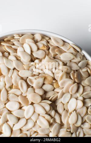 vista dall'alto dei semi di egusi nigeriani in una ciotola bianca, vista dall'alto dei semi di melone sgusciati in una ciotola, dei semi di melone nigeriani e dei semi di zucca per cucinare Foto Stock