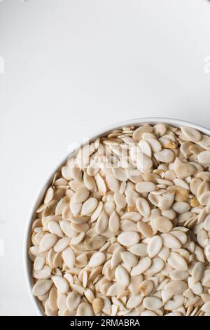 vista dall'alto dei semi di egusi nigeriani in una ciotola bianca, vista dall'alto dei semi di melone sgusciati in una ciotola, dei semi di melone nigeriani e dei semi di zucca per cucinare Foto Stock