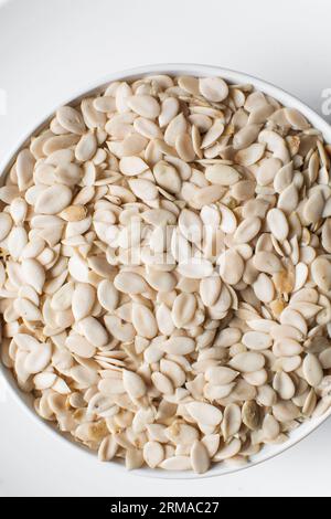 vista dall'alto dei semi di egusi nigeriani in una ciotola bianca, vista dall'alto dei semi di melone sgusciati in una ciotola, dei semi di melone nigeriani e dei semi di zucca per cucinare Foto Stock