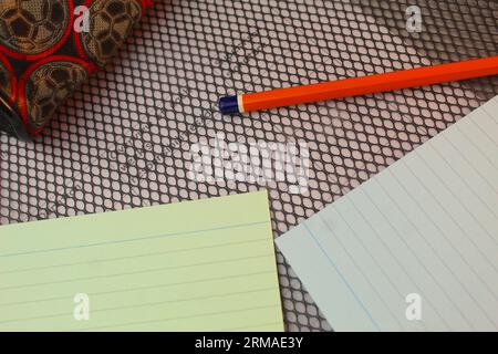 Una foto delle flashcard, della matita e del portamatite di uno studente scolastico sopra una cartella. Foto Stock