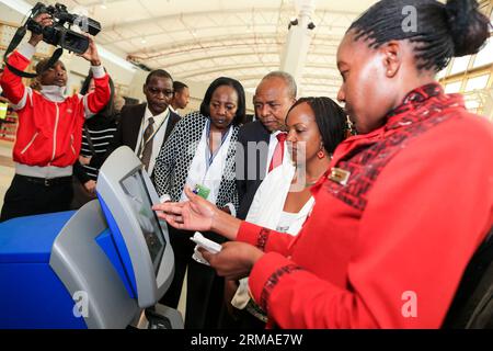 (140704) -- NAIROBI, 4 luglio 2014 (Xinhua) -- il segretario del governo keniota per i trasporti e le infrastrutture Michael Kamau (3rd R) ispeziona le attrezzature self-service di check-in presso il nuovo terminal dell'aeroporto internazionale Jomo Kenyatta (JKIA) di Nairobi, capitale del Kenya, 4 luglio 2014. Il nuovo edificio del terminal JKIA, costruito dalla Aviation Industry Corporation of China (AVIC) International Holding Corporation, ha iniziato un test venerdì. L'edificio, con un'area di costruzione di 25.000 metri quadrati, inizierà un'operazione di prova di tre settimane l'8 luglio. (Xinhua/Meng Chenguang) KENYA-NAIROBI-AIRPORT-NEW ter Foto Stock