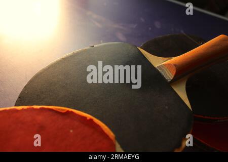 Una foto di due racchette da ping pong su un tavolo da ping pong. Foto Stock