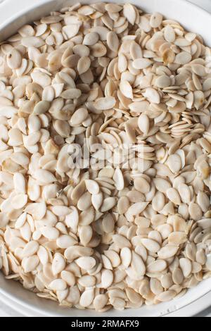 vista dall'alto dei semi di egusi nigeriani in una ciotola bianca, vista dall'alto dei semi di melone sgusciati in una ciotola, dei semi di melone nigeriani e dei semi di zucca per cucinare Foto Stock