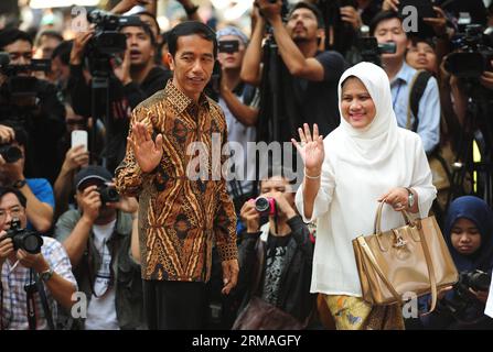 (140709) -- GIACARTA, 9 luglio 2014 (Xinhua) -- candidato presidenziale del Partito Democratico della lotta indonesiano (PDI-P) Joko Widodo (L, fronte) e sua moglie Iriana (R, fronte) salutano le persone in un seggio elettorale a Giacarta, Indonesia, 9 luglio 2014. Gli indonesiani mercoledì sono andati a sondaggi per prendere il loro nuovo presidente per il paese. (Xinhua/Zulkarnain) INDONESIA-GIACARTA-ELEZIONI PRESIDENZIALI PUBLICATIONxNOTxINxCHN Giacarta 9 luglio 2014 XINHUA candidato presidenziale del Partito Democratico Indonesiano della lotta PDI P Joko Widodo l Front e sua moglie l Front salutano celebrità IN una stazione di polling Foto Stock