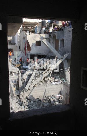 (140710) - Gaza, 10 luglio 2014 (Xinhua) - i soccorritori palestinesi e i residenti ispezionano un edificio colpito da un attacco aereo israeliano che uccise otto persone il 10 luglio 2014 nella città meridionale di Khan Yunis nella Striscia di Gaza. Il ministero della salute ha detto in una dichiarazione stampa che 81 palestinesi sono stati uccisi e 567 feriti negli attacchi aerei israeliani sulla Striscia di Gaza, aggiungendo che il 70% delle vittime sono civili, la maggior parte delle quali donne e bambini. Mentre l'aviazione israeliana ha colpito durante la notte più di 300 bersagli Hamas nella Striscia di Gaza in risposta al fuoco missilistico dal territorio palestinese assediato, un esercito Foto Stock