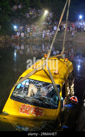 (140711) -- CHANGSHA, 11 luglio 2014 (Xinhua) -- Un autobus per l'asilo viene trainato da uno stagno nel villaggio montuoso di Ganzi nel distretto Yuelu di Changsha, capitale della provincia di Hunan della Cina centrale, 11 luglio 2014. Tutte le 11 persone a bordo, ossia otto bambini dell'asilo, due insegnanti e l'autista, sono morte dopo che il minivan è caduto nello stagno giovedì pomeriggio. L'autobus stava quindi portando i bambini a casa dall'asilo Lelewang al villaggio di Jinqiao nella città di Xiangtan, adiacente a Changsha. (Xinhua/Bai Yu) (ry) FOCUS HUNAN-CHANGSHA-KINDERGARTEN MINIVAN-INCIDENTE (CN) PUBLICATIONxN Foto Stock