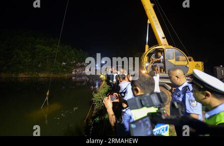 (140711) -- CHANGSHA, 11 luglio 2014 (Xinhua) -- Un autobus per l'asilo viene trainato da uno stagno nel villaggio montuoso di Ganzi nel distretto Yuelu di Changsha, capitale della provincia di Hunan della Cina centrale, 11 luglio 2014. Tutte le 11 persone a bordo, ossia otto bambini dell'asilo, due insegnanti e l'autista, sono morte dopo che il minivan è caduto nello stagno giovedì pomeriggio. L'autobus stava quindi portando i bambini a casa dall'asilo Lelewang al villaggio di Jinqiao nella città di Xiangtan, adiacente a Changsha. (Xinhua/Bai Yu) (ry) FOCUS HUNAN-CHANGSHA-KINDERGARTEN MINIVAN-INCIDENTE (CN) PUBLICATIONxN Foto Stock