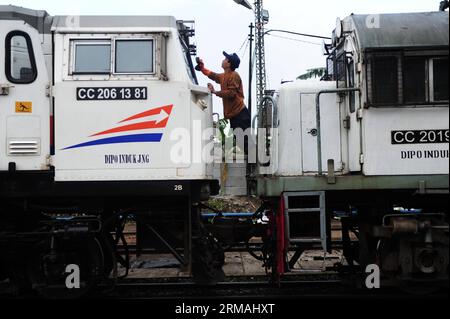 (140711) -- GIACARTA, 11 luglio 2014 (Xinhua) -- Un lavoratore pulisce una locomotiva in preparazione del festival Eid al-Fitr in un impianto di manutenzione a Giacarta, Indonesia, 11 luglio 2014. Ogni anno il traffico indonesiano raggiunge il suo picco durante il periodo di viaggio, mentre milioni di persone viaggiano verso la loro città natale in aereo, nave, auto o moto per celebrare il festival Eid al-Fitr. (Xinhua/Zulkarnain) INDONESIA-GIACARTA-MANUTENZIONE LOCOMOTIVA PUBLICATIONxNOTxINxCHN Giacarta 11 luglio 2014 XINHUA a Worker pulisce una locomotiva in preparazione del giuramento al Fitr Festival PRESSO un impianto di manutenzione a Giacarta Indonesia luglio Foto Stock