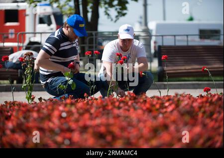 (140716) -- MOSCA, 16 luglio 2014 (Xinhua) -- due uomini posero fiori vicino alla stazione di Park Pobedy il 16 luglio 2014, a Mosca, in Russia. I residenti di Mosca hanno posato fiori e candele accese alla stazione della metropolitana per trasmettere le loro condoglianze alle vittime del letale deragliamento della metropolitana di Mosca. Secondo le ultime statistiche, almeno 22 persone sono morte e altre centinaia sono rimaste ferite in un deragliamento della metropolitana martedì, che è diventato il peggior incidente nella storia della metropolitana di Mosca risalente al 1935. (Xinhua/dai Tianfang) RUSSIA-MOSCA-VITTIME DELLA METROPOLITANA-CONDOGLIANZE PUBLICATIONxNOTxINxCHN Mosca 1 luglio Foto Stock