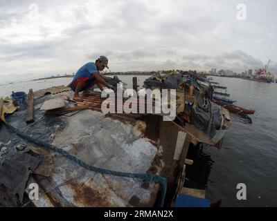 (140717) -- MANILA, 17 luglio 2014 (Xinhua) -- Un uomo ripara il tetto della sua casa dopo che è stato danneggiato dal tifone Rammasun in una zona slum a Manila, nelle Filippine, il 17 luglio 2014. Il bilancio delle vittime dal tifone Rammasun è salito a 38, l'agenzia locale per i disastri ha detto giovedì. Il National Disaster Risk Reduction and Management Council (NDRRMC) ha detto che il tifone ha anche lasciato 10 persone ferite, mentre altre otto sono state dichiarate dispersi. (Xinhua/Rouelle Umali) FILIPPINE-MANILA-TYPHOON RAMMASUN-AFTERMATH PUBLICATIONxNOTxINxCHN Manila 17 luglio 2014 XINHUA A a Man REPAIR the Roof of HIS Home After IT What d Foto Stock