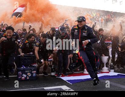 Max Verstappen della Red Bull Racing festeggia la vittoria del Gran Premio d'Olanda con la sua squadra dopo il Gran Premio d'Olanda 2023 sul circuito Zandvoort CM.com a Zandvoort, Paesi Bassi. Data foto: Domenica 27 agosto 2023. Foto Stock