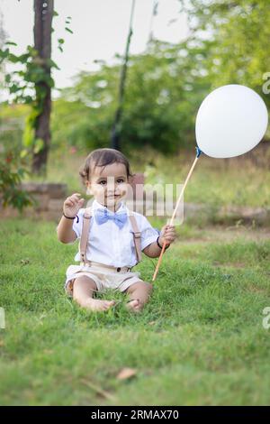 bambino piccolo isolato con un'espressione facciale innocente all'aperto da un'angolazione diversa durante il giorno Foto Stock