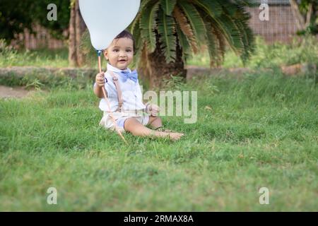 bambino piccolo isolato con un'espressione facciale innocente all'aperto da un'angolazione diversa durante il giorno Foto Stock