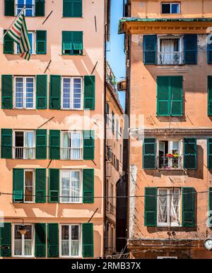 Facciate di due edifici residenziali simili nel centro di Genova, Italia. Una rinnovata sulla sinistra e una vecchia sulla destra. Foto Stock