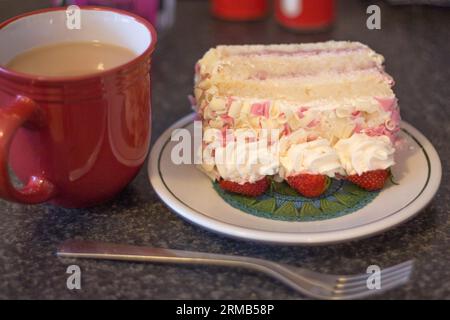 Tazza di tè pomeridiano o caffè mattutino con una fetta di fragola rosa e torta alla panna per un'occasione speciale Foto Stock