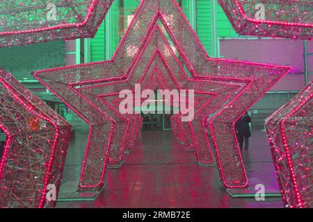 decorazioni natalizie di strada tunnel leggero a forma di stella rosa nello stile di barbie, zona foto di un luogo. Foto Stock