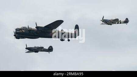 Il Battle of Britain Memorial Flight of Hawker Hurricane PZ865 (a destra), il bombardiere Lancaster PA474 (al centro) e Mk Vb Spitfire, AB910 (a sinistra) si imbattono nello show per eseguire la loro esibizione, durante il Rhyl Air Show 2023 a Rhyl Seafront, Rhyl, Regno Unito, 27 agosto 2023 (foto di Cody Froggatt/News Images) Foto Stock