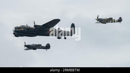 Rhyl, Regno Unito. 27 agosto 2023. Il Battle of Britain Memorial Flight of Hawker Hurricane PZ865 (a destra), il bombardiere Lancaster PA474 (al centro) e Mk Vb Spitfire, AB910 (a sinistra) si imbattono nello show per esibirsi durante il Rhyl Air Show 2023 a Rhyl Seafront, Rhyl, Regno Unito, il 27 agosto 2023 (foto di Cody Froggatt/News Images) a Rhyl, Regno Unito il 8/27/2023. (Foto di Cody Froggatt/News Images/Sipa USA) credito: SIPA USA/Alamy Live News Foto Stock