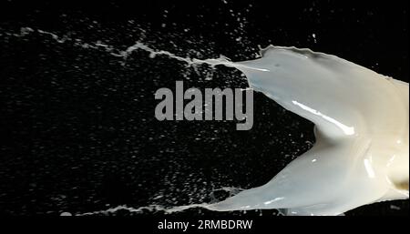 Esplosione del latte su sfondo nero Foto Stock