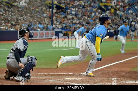 St Petersburg, Stati Uniti. 27 agosto 2023. Il ricevitore dei New York Yankees Kyle Higashioka (L) guarda come Harold Ramirez dei Tampa Bay Rays colpisce un singolo a due punti contro Ian Hamilton, il soldato di Newq York, durante il sesto inning di una partita di baseball al Tropicana Field di St. Petersburg, Florida domenica 27 agosto 2023. Foto di Steve Nesius/UPI. Crediti: UPI/Alamy Live News Foto Stock