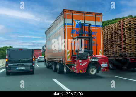 Germania - 01 agosto 2023: Carrelli elevatori a forche montati su autocarri, noti anche come carrelli elevatori a forche piggyback che viaggiano in autostrada durante il traffico intenso Foto Stock