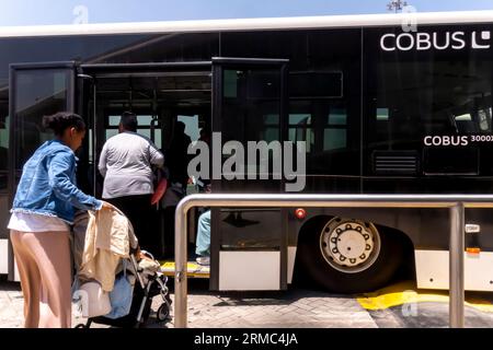 I passeggeri che salgono sulla navetta aeroportuale all'aeroporto di Dubai Foto Stock