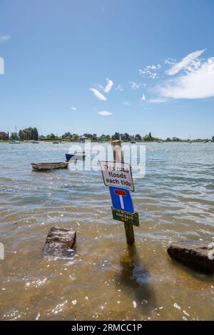 Avviso: "Questa strada inonda ogni marea", Shore Road, Bosham, un villaggio costiero nel porto di Chichester sulla costa meridionale, nel West Sussex durante l'alta marea Foto Stock